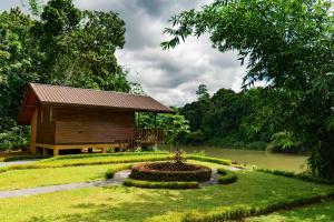a small cabin with a fountain in the middle of a garden at Kandy Cabana in Kandy