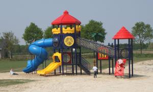 a playground with a slide in the sand at Groepsaccommodatie Vollenhove in Vollenhove