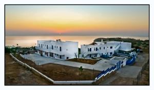 un groupe de bâtiments blancs avec l'océan en arrière-plan dans l'établissement Bella Vista Stegna, à Archangelos