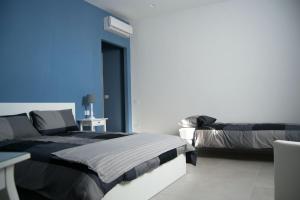 a bedroom with two beds and a blue wall at "Panoramic Terrazza - Napoli" in Naples