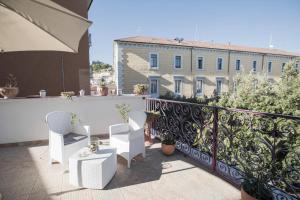 un balcón con sillas blancas y un edificio en B&B Terrazza Flora en Campobasso