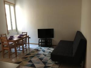 un soggiorno con tavolo e TV di Appartamento Mosaico 22161 a Rovereto