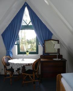 a bedroom with a table and chairs and a window at FH Austernfischer I/Nr. 1 in Spiekeroog