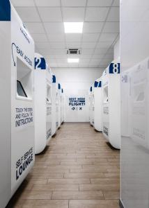 a row of white toilets in a room at Resting Pods - ZZZleepandGo BGY Airport in Orio al Serio