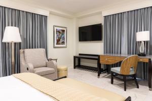 ein Hotelzimmer mit einem Bett, einem Schreibtisch und einem Stuhl in der Unterkunft The Jung Hotel and Residences in New Orleans