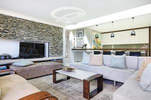 a living room with two couches and a tv at Blinkwater Villa in Cape Town