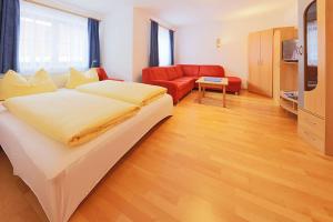 1 dormitorio con 1 cama grande y 1 sofá rojo en Appartement Andreas Gstrein, en Sölden