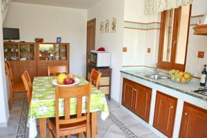 a kitchen with a table with a bowl of fruit on it at Costa Mediterranea Holiday Homes in Campofelice di Roccella