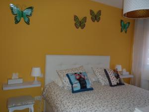 a bedroom with a bed with butterflies on the wall at El Balconcito de San Millan II in Segovia