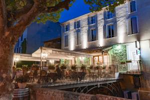 a restaurant with tables and chairs in front of a building at Hotel Restaurant des Maures in Collobrières
