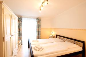 ビンツにあるHaus & Villa Strandidyll by Rujanaのベッドルーム1室(白いシーツ付きのベッド1台、窓付)