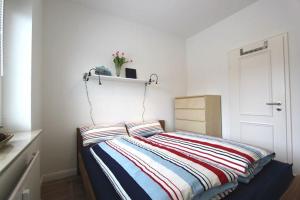 Schlafzimmer mit einem Bett mit gestreifter Decke in der Unterkunft Robbe in Hörnum