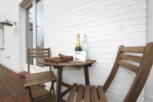 einen Tisch mit einer Flasche Wein und zwei Stühlen in der Unterkunft Robbe in Hörnum