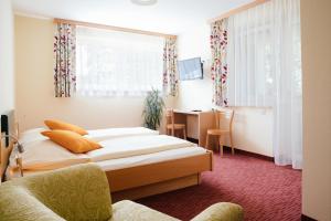 a hotel room with two beds and a desk at Gasthof Martinhof in Sankt Martin im Sulmtal