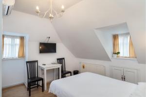 1 dormitorio con 1 cama, escritorio y 2 sillas en Casa Astronomului, en Sibiu
