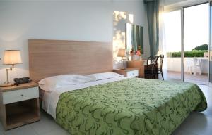 a bedroom with a large bed with a green blanket at Hotel Loreley in Ischia