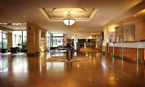 a lobby with a large lobby with a table and chairs at Millennium Hotel Paris Charles De Gaulle in Roissy-en-France +52 photos