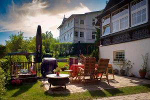 eine Terrasse mit einem Tisch und Stühlen sowie ein Gebäude in der Unterkunft Ferienwohnungen am Nationalpark in Sassnitz