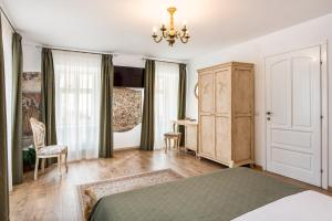 Un dormitorio con una cama, un escritorio y una lámpara de araña. en Casa Astronomului, en Sibiu