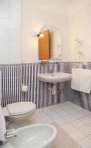 bagno con lavandino, servizi igienici e specchio di Hotel Loreley a Ischia