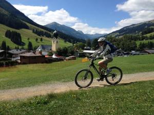 una persona montando una bicicleta por un camino de tierra en Ferienwohnung Loitfelder-Pang, en Saalbach Hinterglemm
