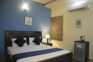 a bedroom with a large bed with a blue wall at Elite Residence in Islamabad
