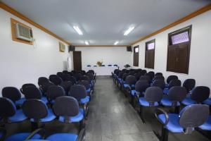 an empty room with blue chairs and a table at Hotel Monte Pascoal in Itamaraju