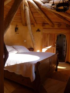 a bedroom with a large bed in a attic at Cabane-hobbit de Samsaget in Eyvignes-et-Eybènes