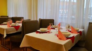 jadalnia z dwoma stołami z czerwonymi serwetkami w obiekcie Hostel Fortis w mieście Ostrołęka