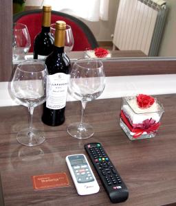 stół z dwoma kieliszkami do wina i pilotem w obiekcie Apartments Skadarlija w Belgradzie
