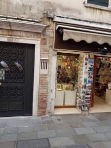 ein Geschäft vor einem Gebäude mit einem Lagerfenster in der Unterkunft Gioiello di Venezia, Suite San Lio in Venedig