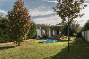 a yard with a swimming pool and a tree at Casa Rural Viña Vella in Esteiro