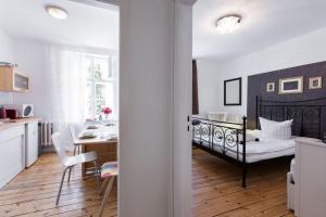 eine Küche und ein Schlafzimmer mit einem Bett in einem Zimmer in der Unterkunft Elegantes 2-Zimmer-Apartment im Kiez von Prenzlauer Berg in Berlin
