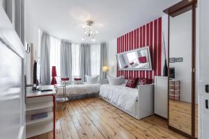 1 dormitorio con cama blanca y pared de rayas rojas y blancas en Elegantes 2-Zimmer-Apartment im Kiez von Prenzlauer Berg en Berlín