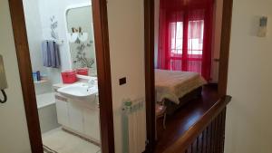 a bathroom with a sink and a bed and a mirror at B&B Verrazzano affittacamere in Sottomarina