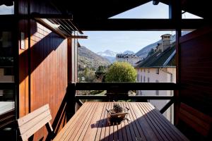 a wooden table on a balcony with a view at Résidence Cybèle in Brides-les-Bains