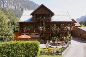 a large wooden house with people sitting outside of it at Haus Sonnbühel in Brand +37 photos