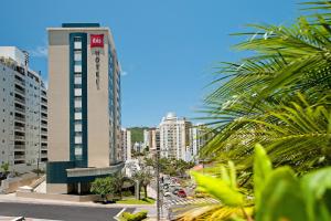 a city street with a tall building with cars at Ibis Florianopolis in Florianópolis
