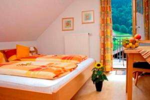 a bedroom with a bed and a table and a balcony at Haus Sonnbühel in Brand