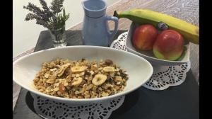 a bowl of cereal with nuts and apples on a table at Apartments Stefani in Fažana