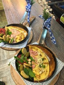 een tafel met twee pizza's en een salade erop. bij Apartments Stefani in Fažana