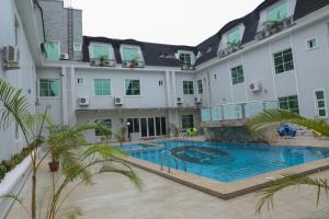 an apartment building with a swimming pool in the courtyard at Heritage Continental Hotel in Akure