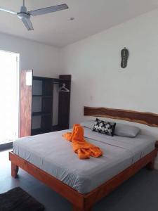 una camera da letto con un letto e un accappatoio arancione sopra di Oasis a Sámara