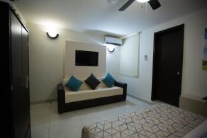 a living room with a couch and a tv at Hotel La Torre San Francisco in San Francisco del Rincón