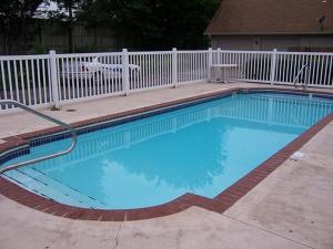 a large blue swimming pool with a white fence at Oak Hill Inn and Suites in Tahlequah