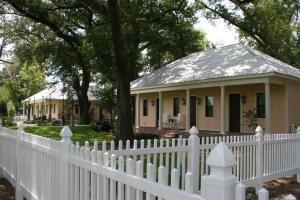 a white picket fence in front of a white house at The Inn at Houmas House Estate in Darrow
