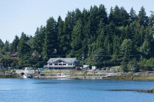 a house on the shore of a body of water at Island West Resort-Motel in Ucluelet