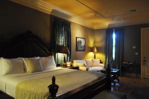 a bedroom with a bed and a chair and a couch at The Inn at Houmas House Estate in Darrow