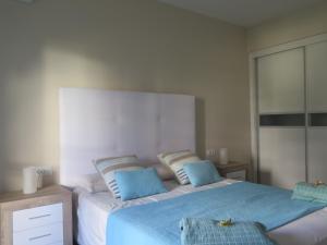ベナルマデナにあるMediterranean Ocean Front Apartmentのベッドルーム(青い枕の大型ベッド1台付)