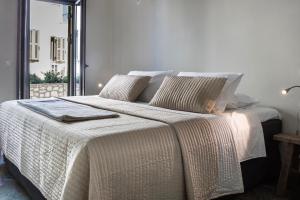a bedroom with a large bed with white sheets and pillows at Myrtos Bay Apartments in Anomeriá +49 photos